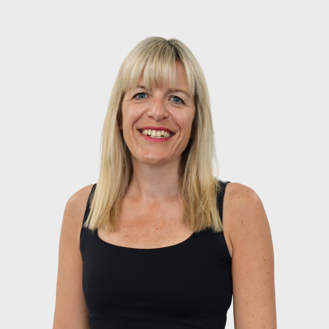Caroline Parr smiling at the camera wearing a black vest top