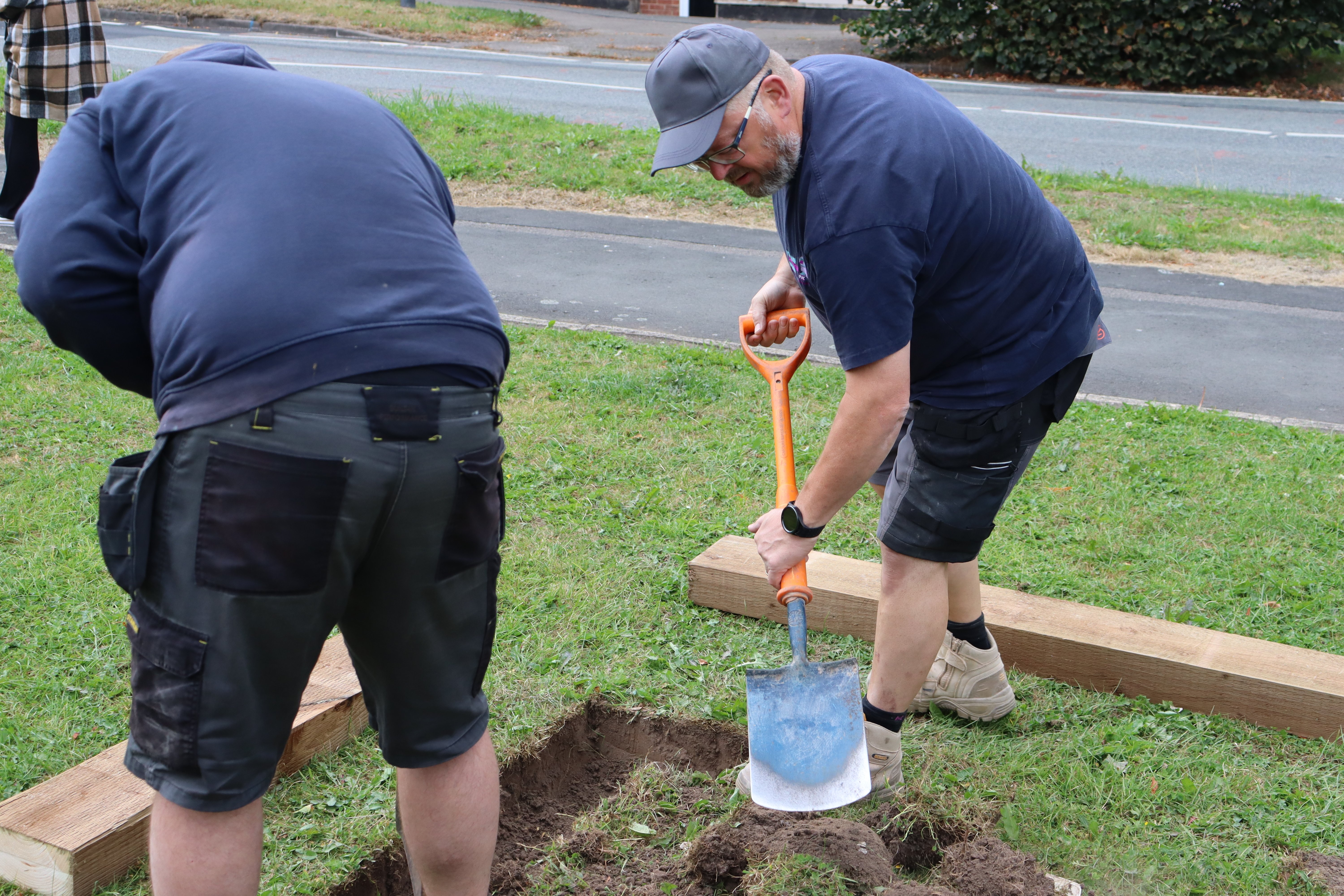 Two men digging into ground