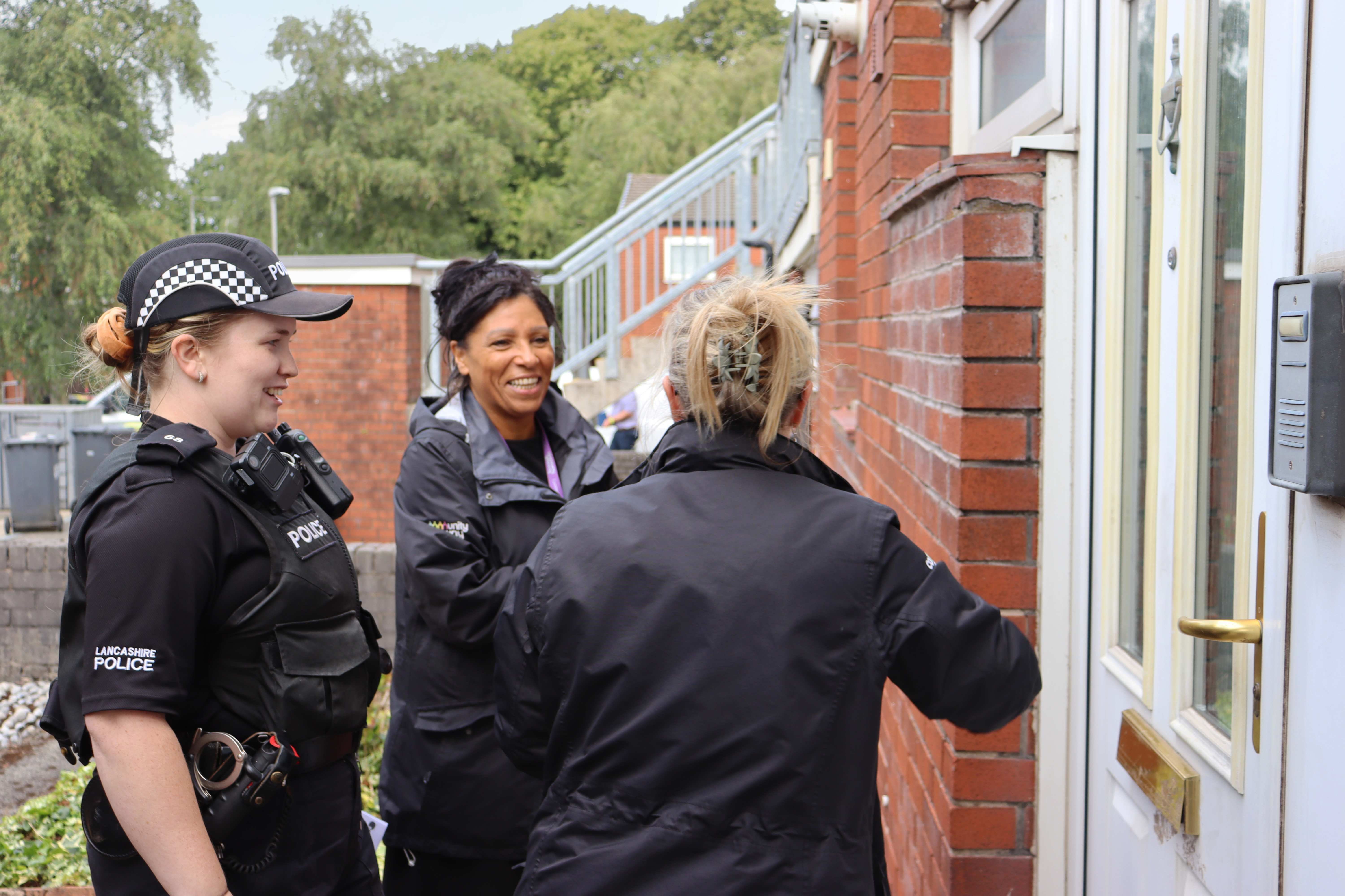 A PCSO and two Community Gateway staff members stood outside a door