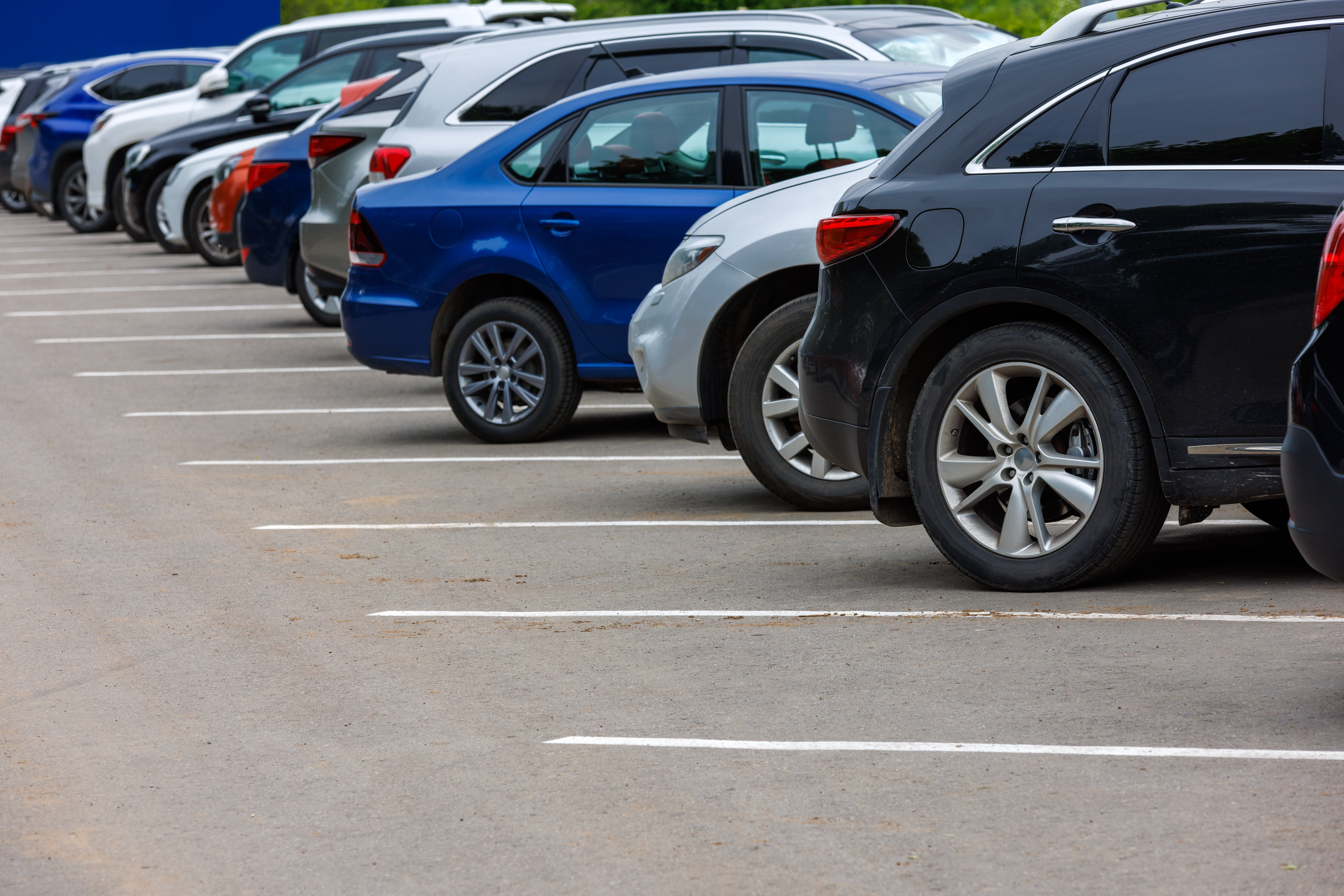 row-different-color-cars-asphalt-parking-lot-cloudy-summer-day
