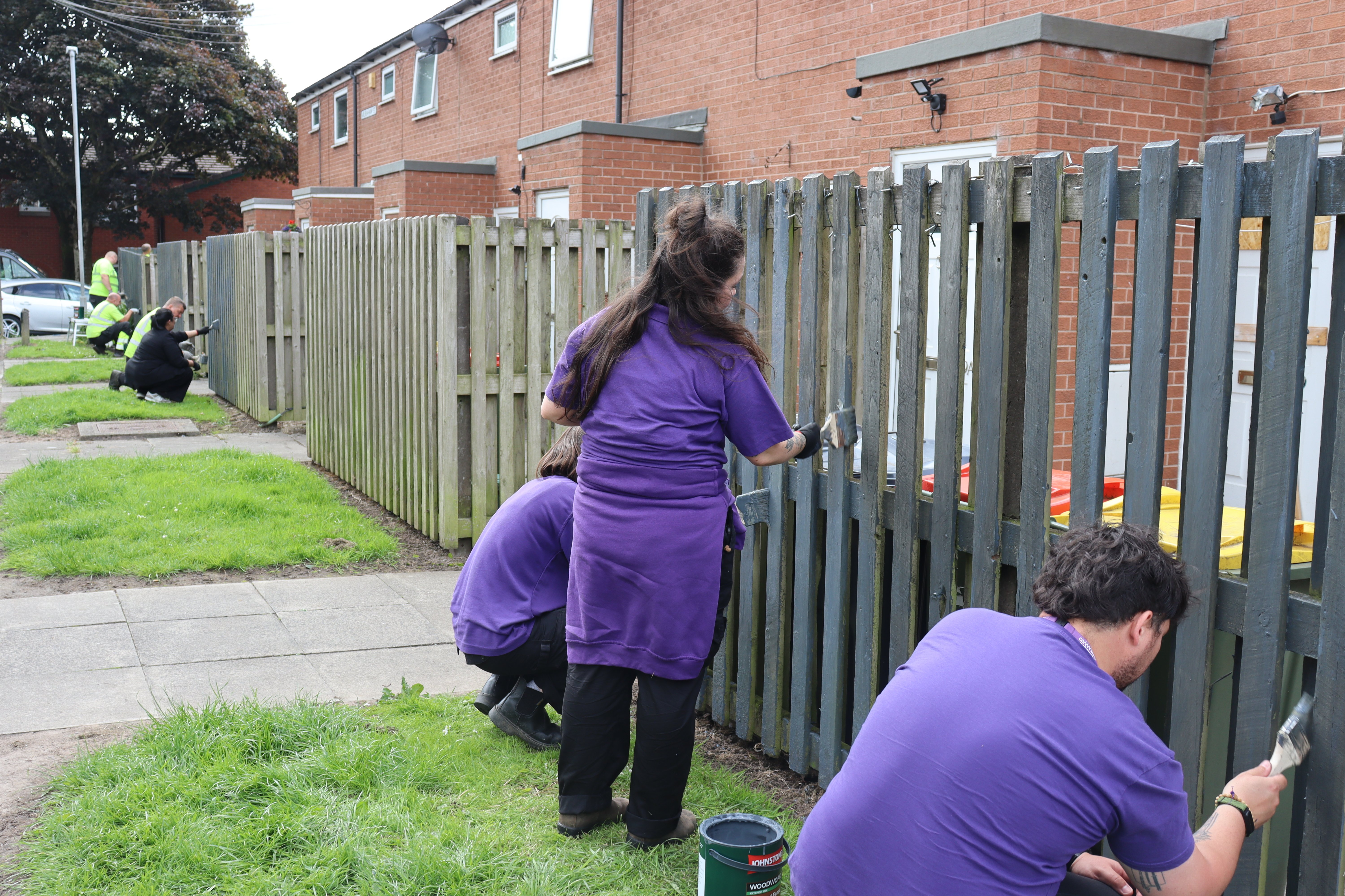CGA teams painting a fence 