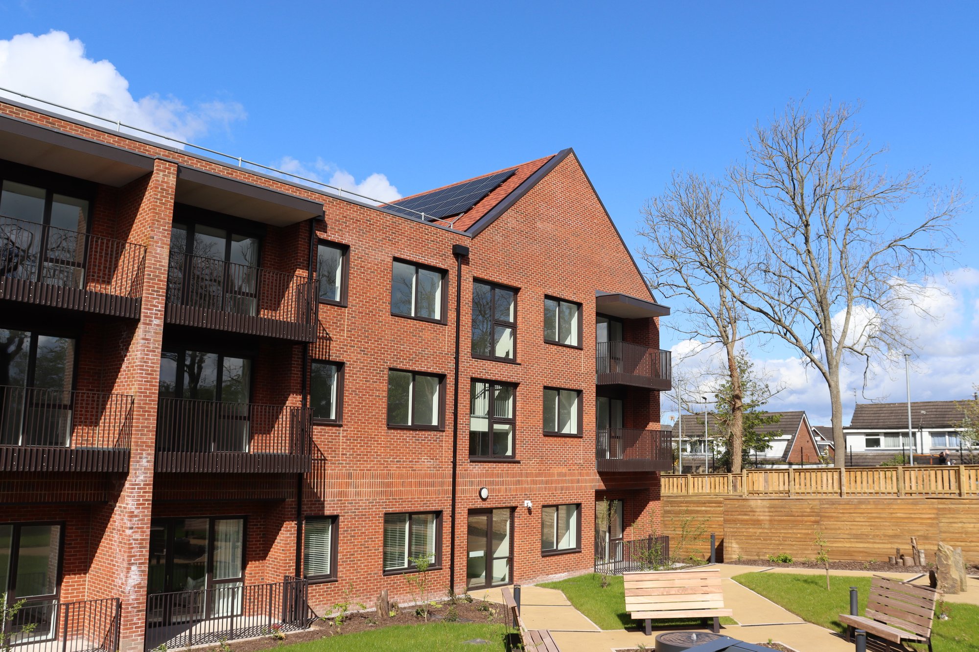 Showing an external view of the accommodation at The Atrium and seating in an outdoor communal space