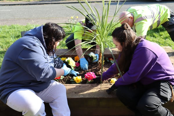 A tenant planting flowers with CGA teams