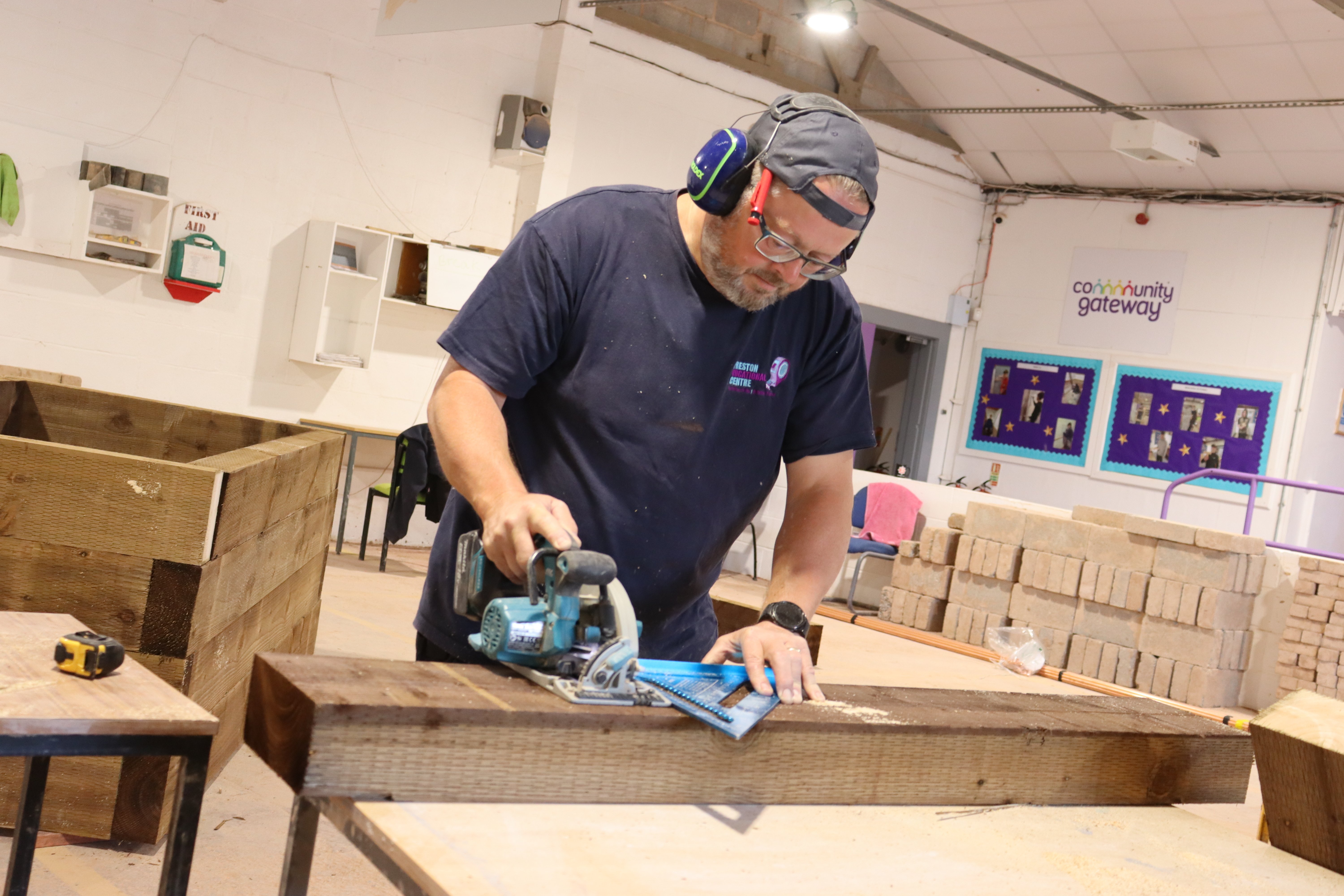 A man with ear defenders on working on a planter
