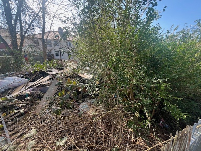 The large scale of fly-tip and weeds before the project began.